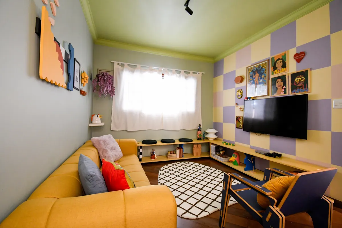 A mesma sala antes e depois do projeto da Orí: de paredes cremes e sofá rosa para parede em xadrez lilás e amarelo, teto verde, sofá amarelo e painel de marcenaria com arte popular brasileira