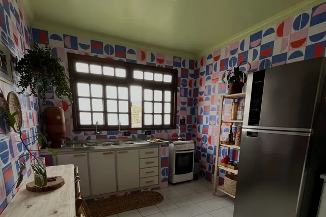 A cozinha depois: paredes com padrão geométrico em azul, vermelho, lilás e creme