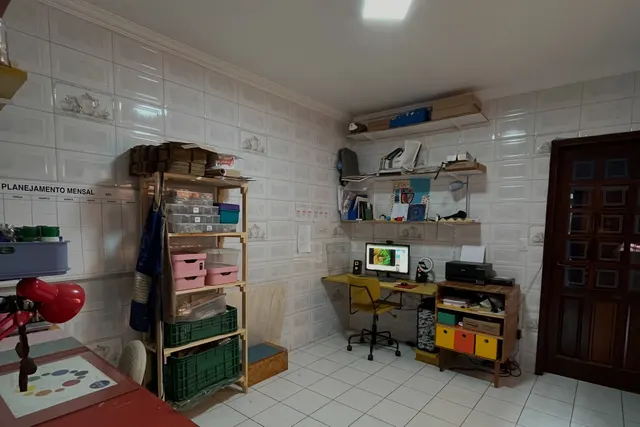 O escritório antes: azulejo branco, estante de ferro e mesa encostada na parede