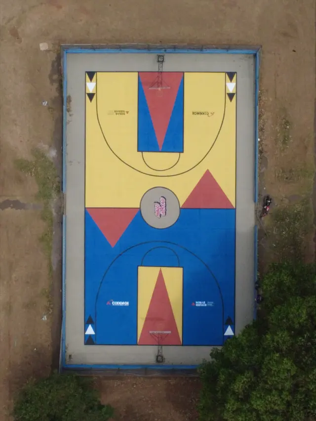 A mesma quadra vista de cima depois: amarelo, azul e vermelho, com triângulos e círculo central