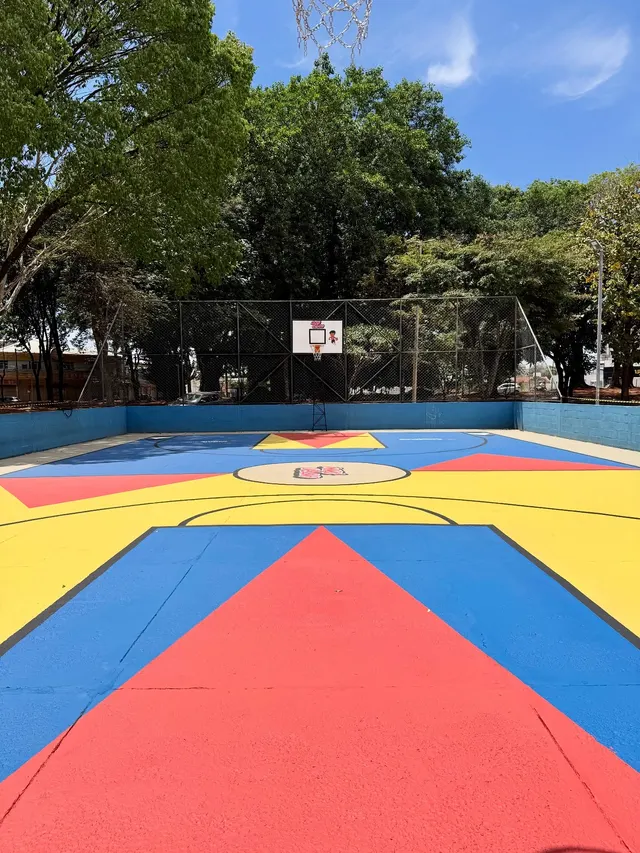 Quadra pronta, pintada em azul, amarelo e vermelho com um grande triângulo vermelho no centro