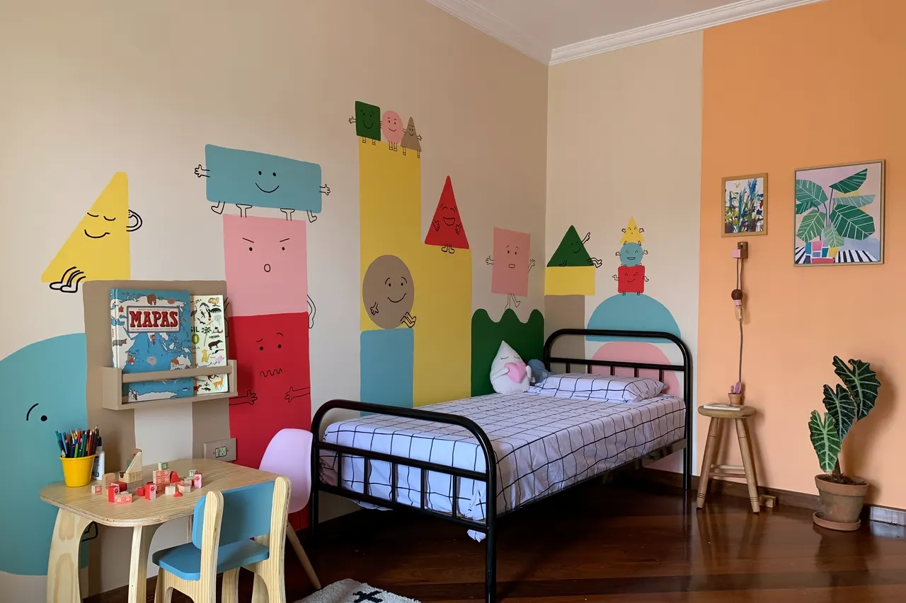 Quarto infantil com mural de personagens geométricos coloridos pintado na parede, cama de ferro preta e mesinha azul