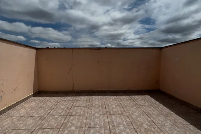 A varanda antes: muro desgastado, piso cerâmico e nenhum móvel